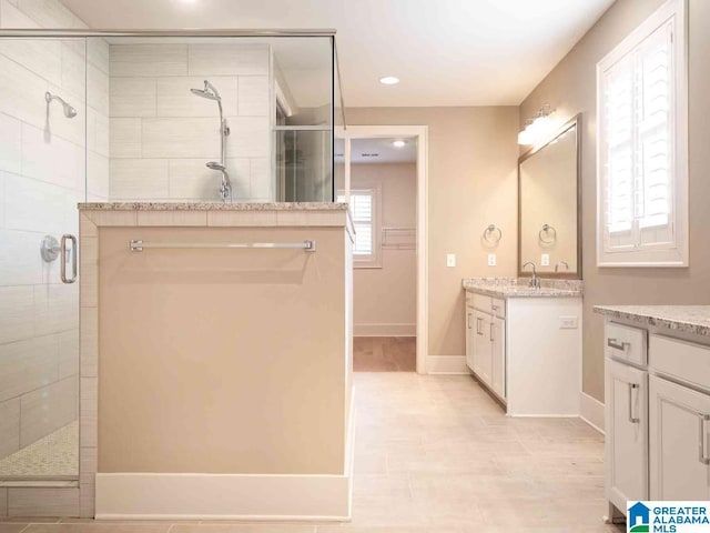 bathroom with vanity and a shower with door