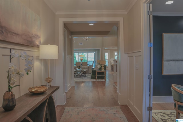 corridor with ornamental molding and light wood-type flooring