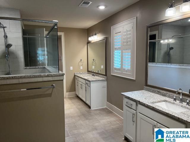 bathroom featuring vanity and a shower with door