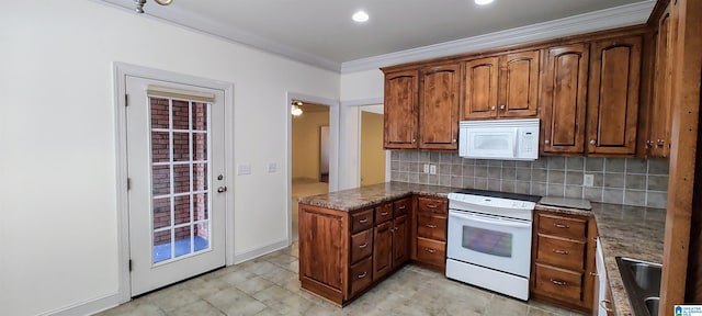 kitchen featuring tasteful backsplash, white appliances, sink, dark stone countertops, and light tile patterned floors