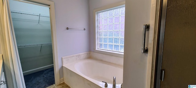 bathroom featuring tile patterned flooring and a tub to relax in