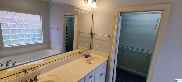 bathroom with dual vanity and a bath