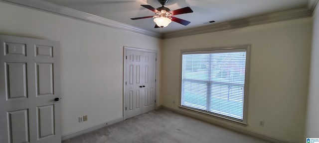 carpeted spare room featuring ornamental molding and ceiling fan