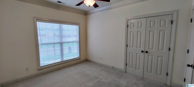 unfurnished bedroom with ornamental molding, light carpet, a closet, and ceiling fan