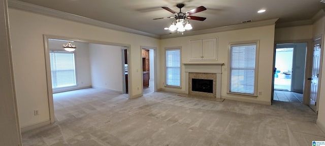 unfurnished living room featuring ornamental molding, light carpet, a fireplace, and ceiling fan