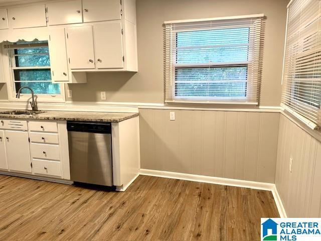 kitchen with sink, white cabinetry, dishwasher, and light hardwood / wood-style flooring