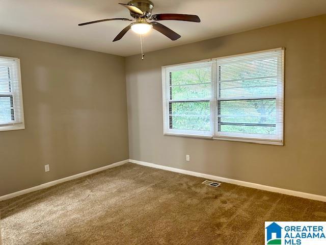 carpeted spare room with ceiling fan