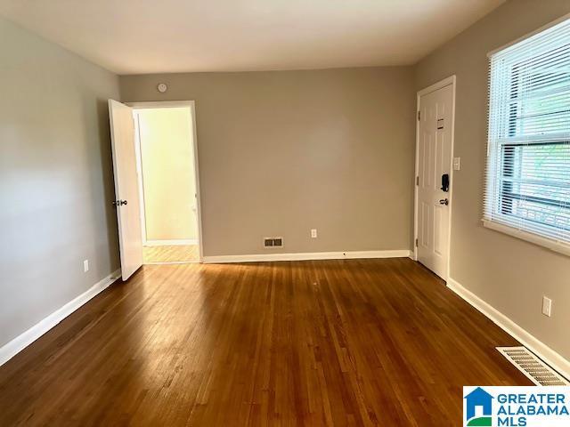 unfurnished room featuring dark hardwood / wood-style flooring