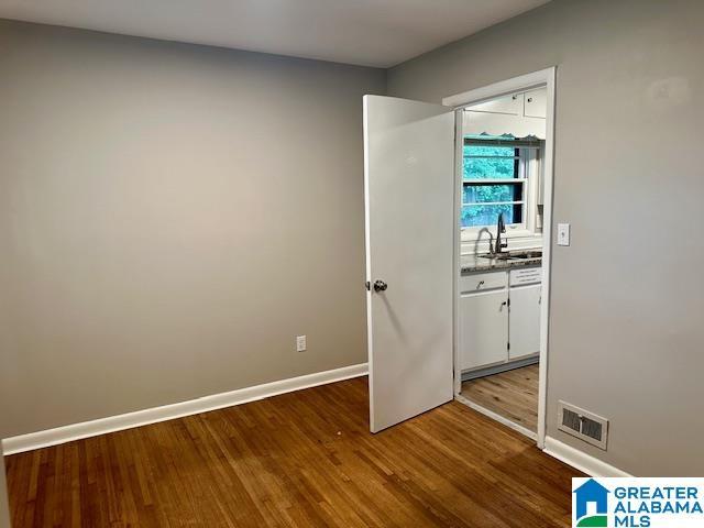 unfurnished bedroom featuring hardwood / wood-style floors and sink