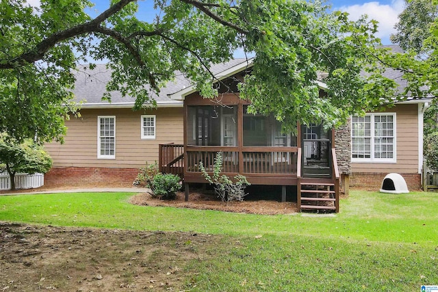 rear view of house with a wooden deck, a sunroom, and a lawn