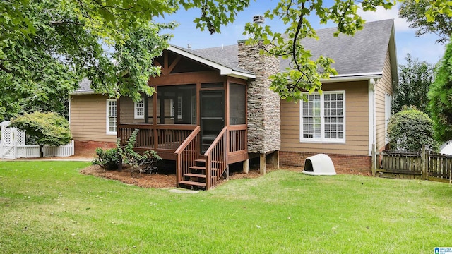 rear view of property with a sunroom and a lawn