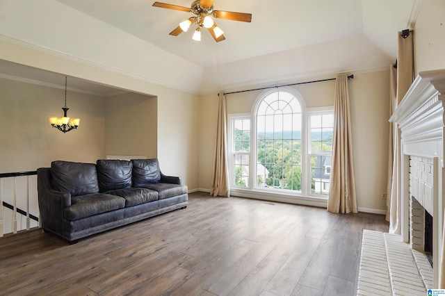 living room with hardwood / wood-style flooring, a fireplace, ceiling fan with notable chandelier, and vaulted ceiling