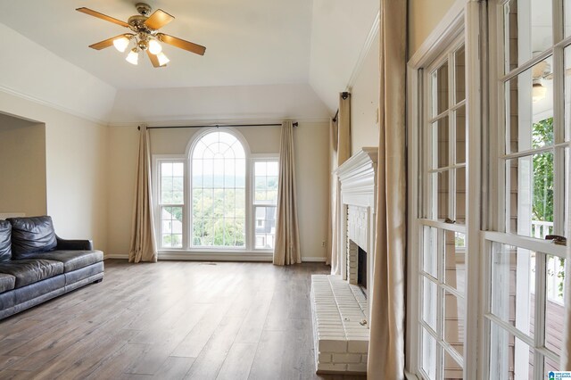 living room with ceiling fan, lofted ceiling, a fireplace, and light hardwood / wood-style flooring