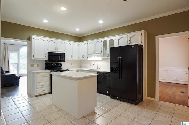 kitchen with light tile patterned floors, sink, white cabinetry, a center island, and black appliances