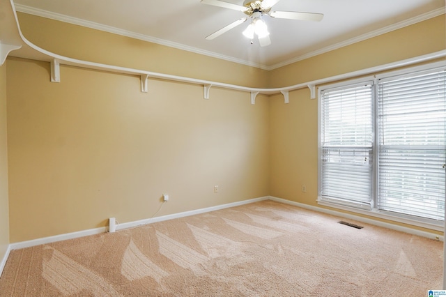 empty room with crown molding, carpet, and ceiling fan