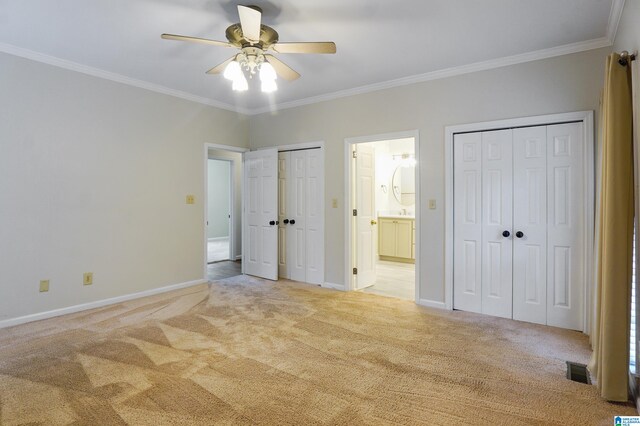 unfurnished bedroom featuring multiple closets, ceiling fan, ornamental molding, and light colored carpet