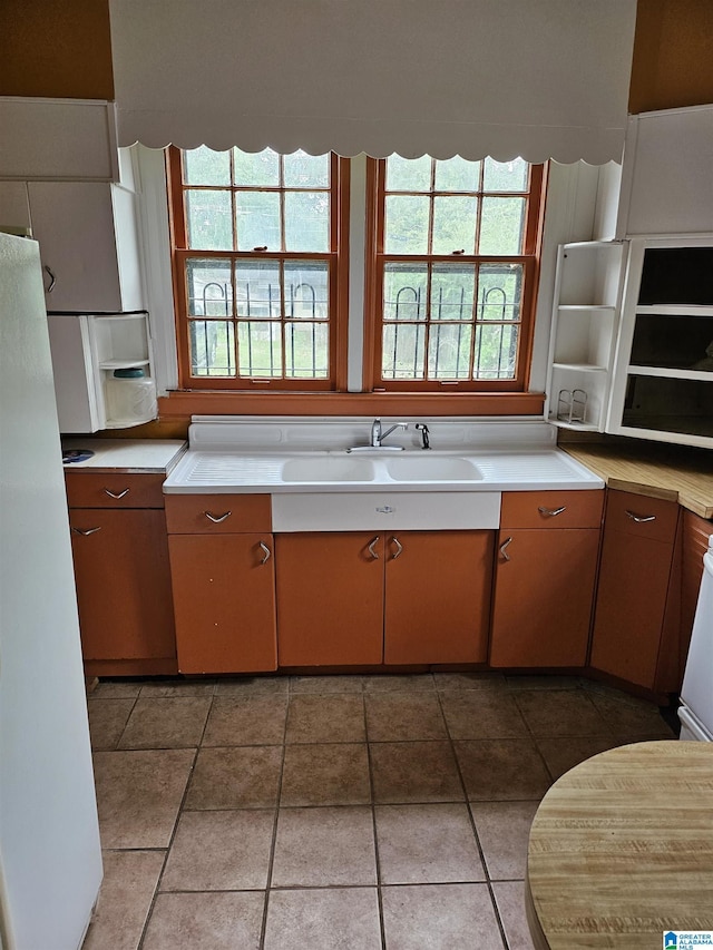 kitchen featuring tile patterned flooring, sink, and white fridge