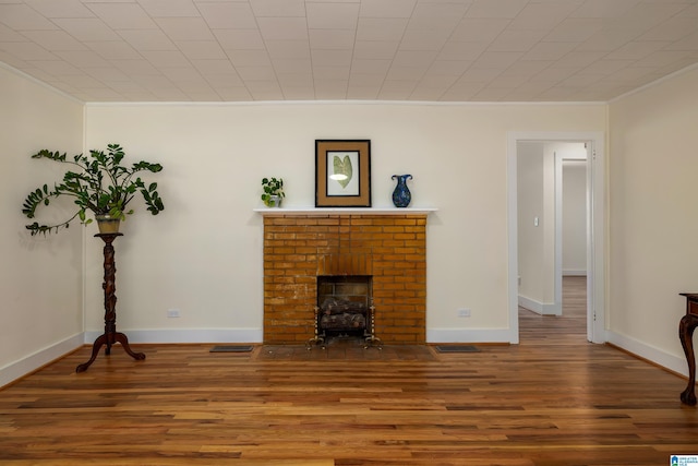 living room with a fireplace, crown molding, and wood-type flooring