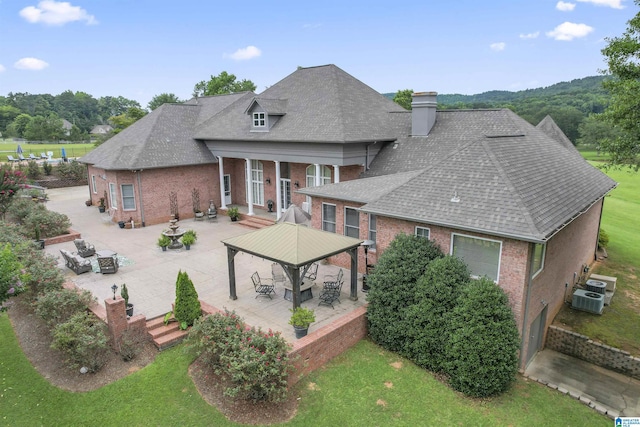 exterior space featuring a gazebo, central air condition unit, a patio, and a lawn