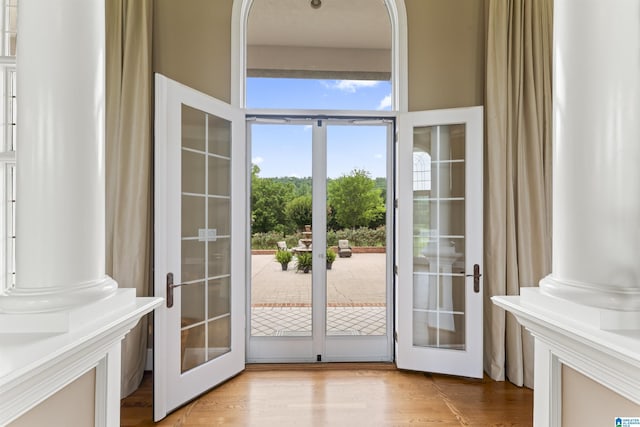 entryway featuring french doors, decorative columns, and light hardwood / wood-style flooring