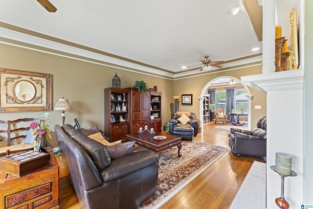 living room with hardwood / wood-style flooring, crown molding, and ceiling fan