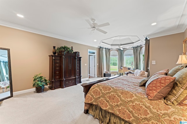 carpeted bedroom with ornamental molding, ceiling fan, and a tray ceiling