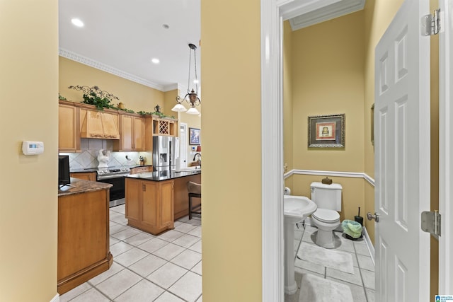 kitchen with backsplash, hanging light fixtures, ornamental molding, a center island, and stainless steel appliances