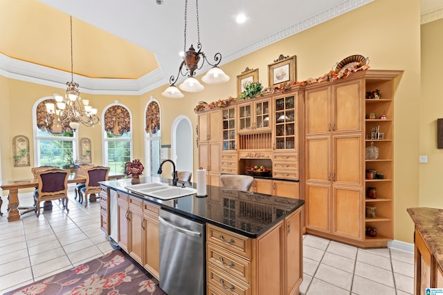 kitchen with light tile patterned flooring, hanging light fixtures, sink, dishwasher, and a kitchen island with sink