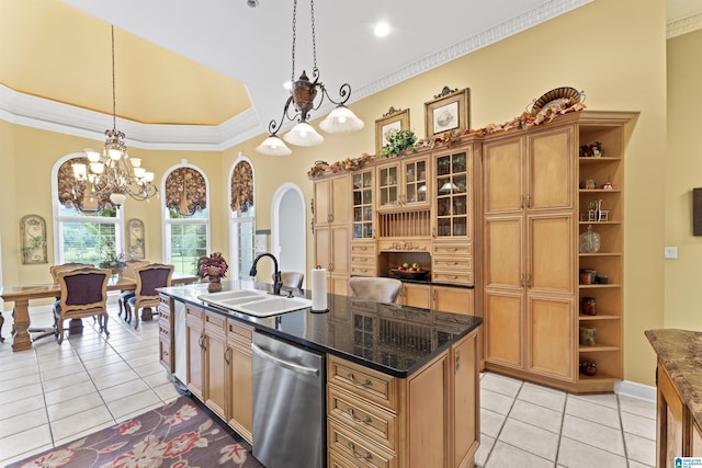 kitchen with light tile patterned flooring, sink, decorative light fixtures, stainless steel dishwasher, and a kitchen island with sink