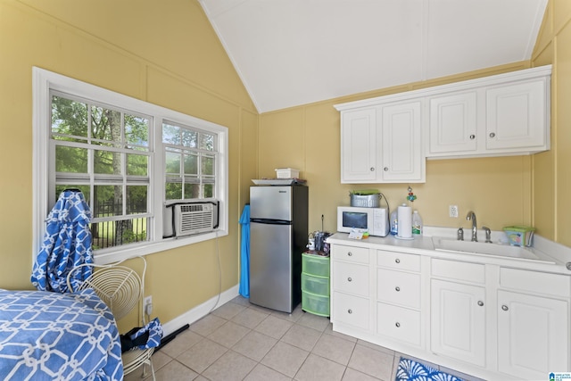 kitchen with vaulted ceiling, sink, cooling unit, white cabinets, and stainless steel fridge