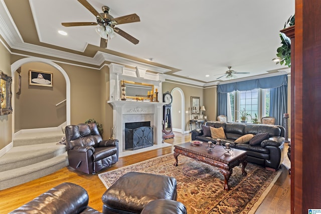 living room featuring hardwood / wood-style floors, ornamental molding, and ceiling fan