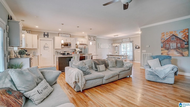 living room featuring light wood-type flooring, ceiling fan, and ornamental molding