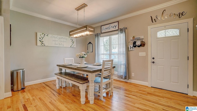 dining area featuring light hardwood / wood-style floors and crown molding