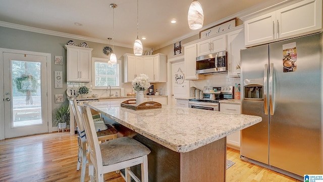 kitchen with light hardwood / wood-style flooring, tasteful backsplash, stainless steel appliances, and decorative light fixtures