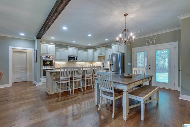 dining room featuring french doors, a chandelier, ornamental molding, beamed ceiling, and light hardwood / wood-style floors