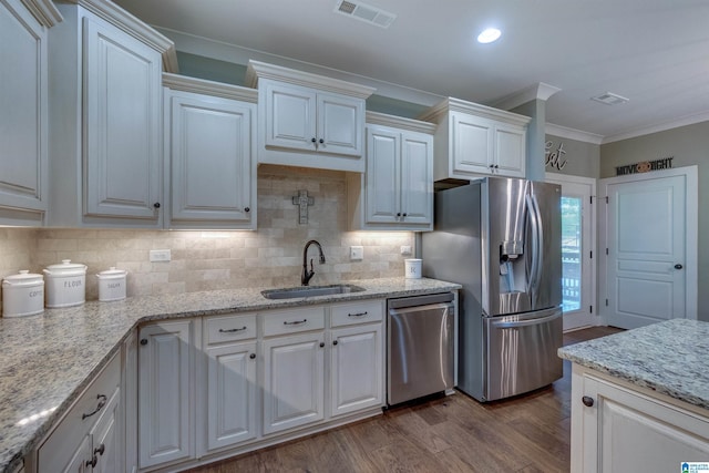 kitchen with dark hardwood / wood-style floors, white cabinetry, sink, decorative backsplash, and stainless steel appliances