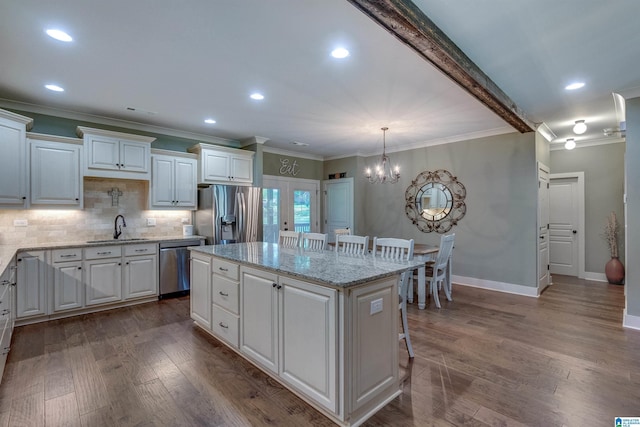 kitchen featuring a center island, a breakfast bar, white cabinets, and appliances with stainless steel finishes