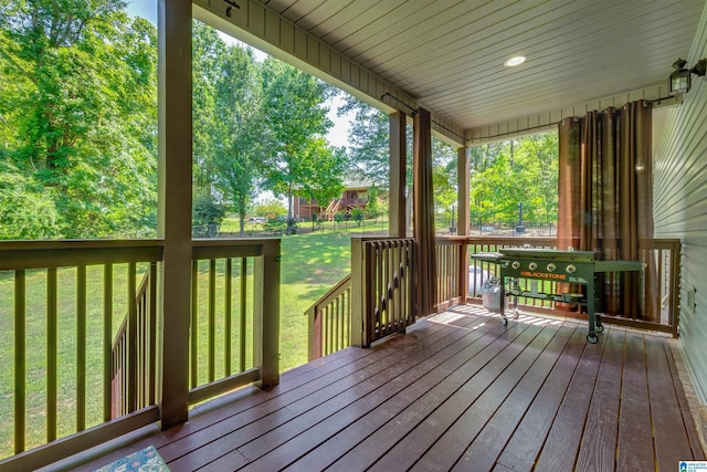 wooden terrace featuring a lawn