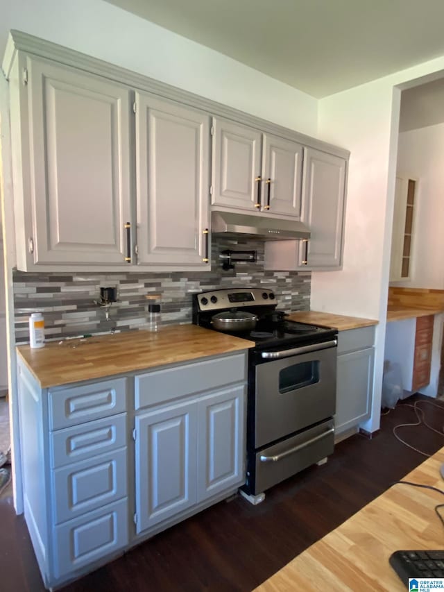 kitchen featuring dark wood-type flooring, electric range, and wood counters