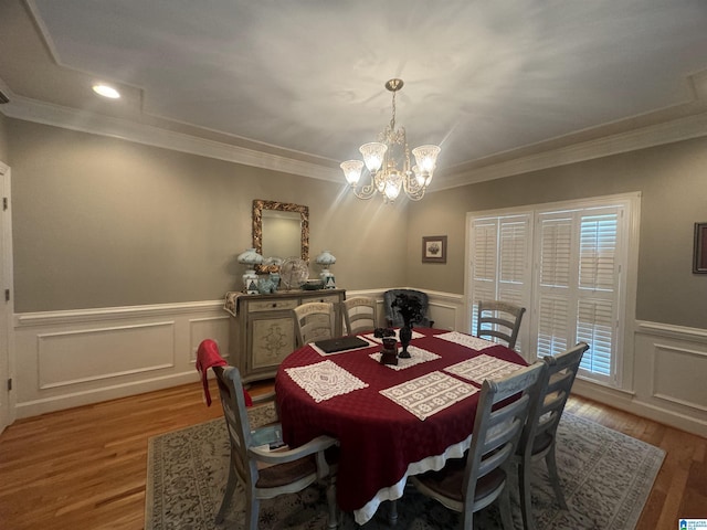 dining area featuring ornamental molding, a notable chandelier, and light wood-type flooring