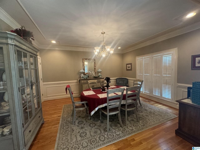 dining space featuring hardwood / wood-style flooring, ornamental molding, and a chandelier