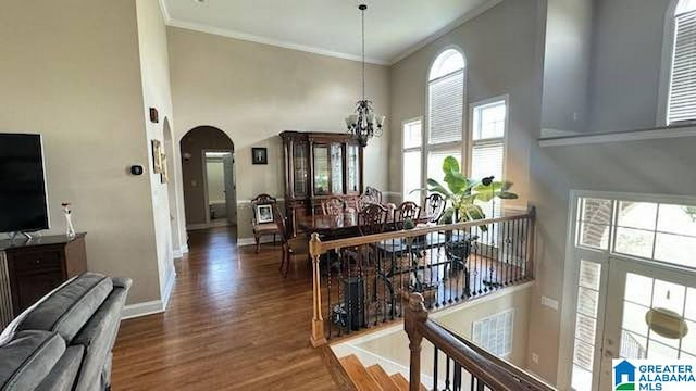 dining room with a chandelier, crown molding, and a towering ceiling