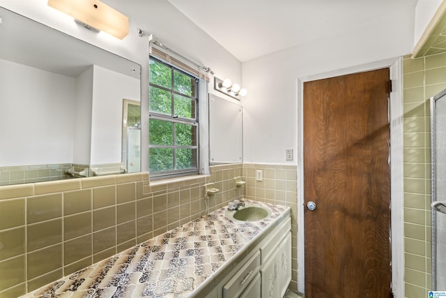 bathroom featuring vanity and tile walls