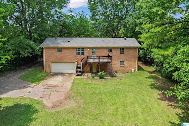 back of property featuring a garage, a yard, and a deck