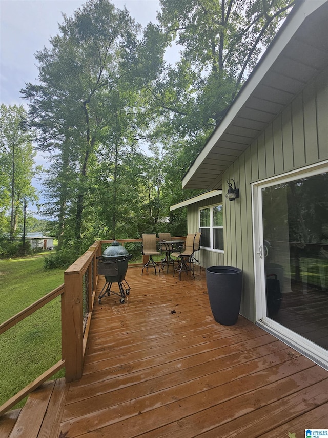 wooden terrace with area for grilling and a yard