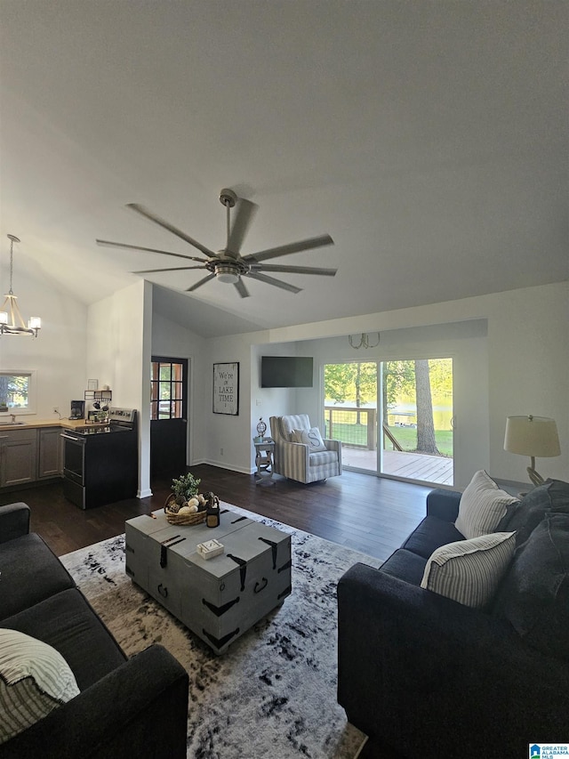 living room featuring ceiling fan with notable chandelier, plenty of natural light, dark hardwood / wood-style floors, and vaulted ceiling