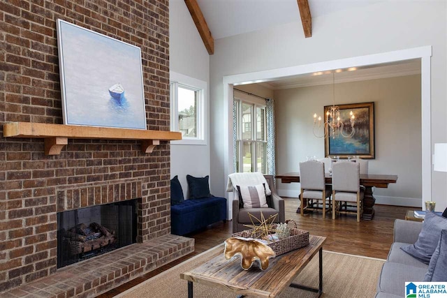 living room with dark hardwood / wood-style floors, a fireplace, vaulted ceiling with beams, and an inviting chandelier