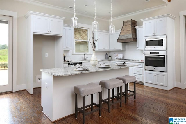 kitchen with stainless steel appliances, a kitchen island, white cabinetry, dark hardwood / wood-style flooring, and custom range hood