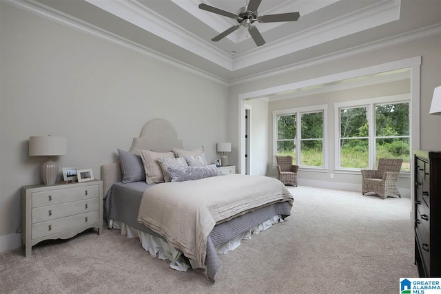 bedroom featuring ornamental molding, light carpet, and a raised ceiling