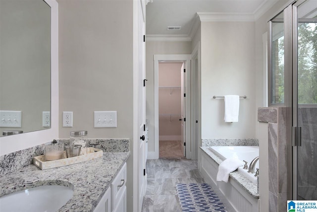 bathroom with tile patterned flooring, a tub to relax in, vanity, and ornamental molding